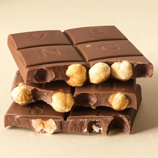 Bruten Venchi mjölkchokladkaka som visar inbäddade rostade hela hasselnötter i gianduja-bas