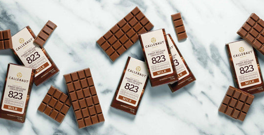 Scattered Callebaut 823 Milk chocolate bars and wrappers