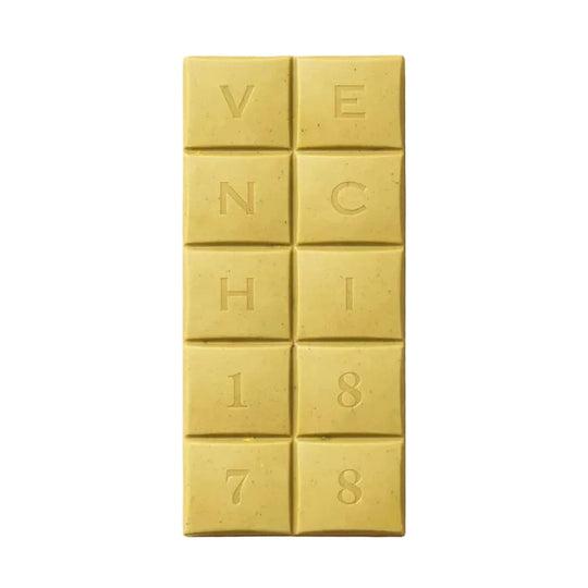 Närbild på Venchi 1878 vitt chokladblock med krispiga pistaschnötter