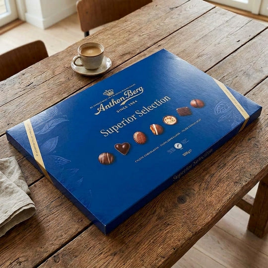 Large Anthon Berg 1000g chocolate gift box on rustic wooden table with coffee