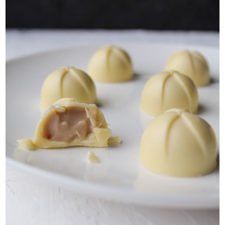 Vit chokladpralin med krämig fyllning uppbiten