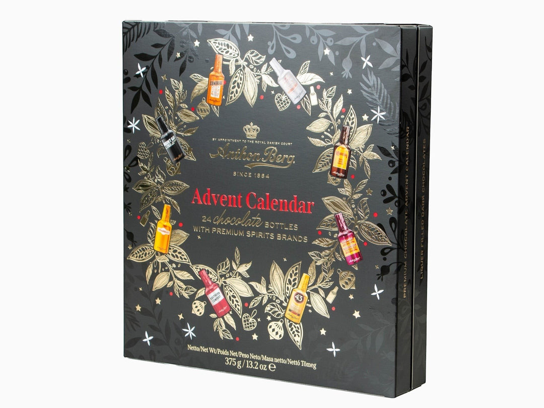 Chokladshopen Anthon Berg likörkalender med 24 chokladflaskor i en svart ask dekorerad med guldfärgade julmotiv