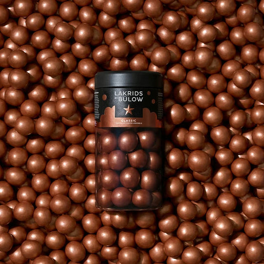 Chokladshopen Lakrids By Bülow Classic lakritskulor täckta med Dulce-choklad och havssalt i en svart burk.