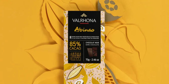 Chokladshopen Valrhona Abinao 85% mörk chokladkaka med elegant och koncentrerad smakprofil på gul bakgrund