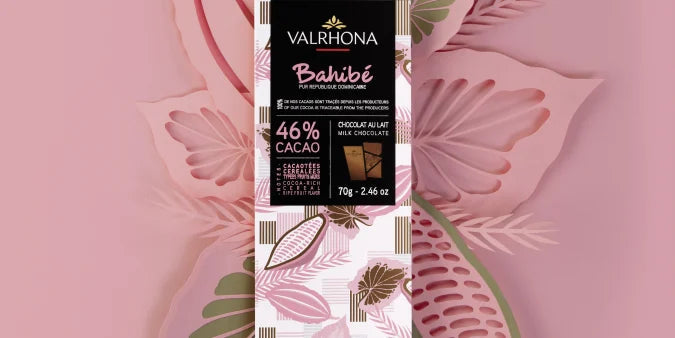 Chokladshopen Valrhona Bahibe 46% mjölkchokladkaka på 70g med elegant förpackning mot en stiliserad blommig bakgrund.