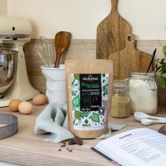 Chokladshopen Valrhona Manjari 64% mörk choklad från Madagaskar i 250g förpackning på en köksbänk med bakredskap.