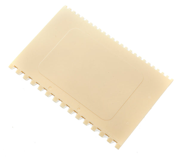 Beige dekorationsskrapa med sågkantade sidor och handtag för chokladdekorering