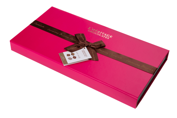 Magenta Grand Pralinask med magnetlås och guldtext, innehåller 26 belgiska praliner